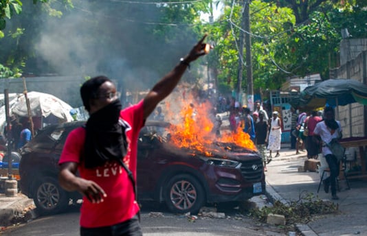 A protester holds up matches after setting a government car on fire during a protest demanding justice for a student who was gunned down by police the previous week at the university where students were protesting on campus for government teaching jobs in Port-au-Prince, Haiti, Monday, Oct. 5, 2020. (AP Photo/Dieu Nalio Chery) A protester holds up matches after setting a government car on fire during a protest demanding justice for a student who was gunned down by police the previous week at the university where students were protesting on campus for government teaching jobs in Port-au-Prince, Haiti, Monday, Oct. 5, 2020. (AP Photo/Dieu Nalio Chery)