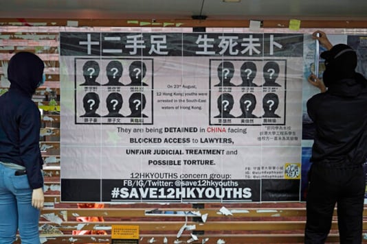 In this Tuesday, Sept. 29, 2020 photo, university students put up posters to demand of releasing the 12 Hong Kong activists detained at sea by Chinese authorities, at a In this Tuesday, Sept. 29, 2020 photo, university students put up posters to demand of releasing the 12 Hong Kong activists detained at sea by Chinese authorities, at a