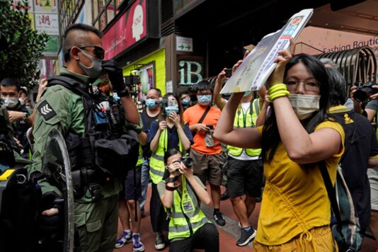 A protester shows a front page of Apple Daily to riot police to demand releasing the 12 Hong Kong activists detained at sea by Chinese authorities, during the China's National Day in Causeway Bay, Hong Kong, on Thursday, Oct. 1, 2020. Hong Kong police have arrested at least 60 people on suspicion of unauthorized assembly on China's National Day holiday after crowds gathered in a popular shopping district chanting pro-democracy slogans. (AP Photo/Kin Cheung) A protester shows a front page of Apple Daily to riot police to demand releasing the 12 Hong Kong activists detained at sea by Chinese authorities, during the China's National Day in Causeway Bay, Hong Kong, on Thursday, Oct. 1, 2020. Hong Kong police have arrested at least 60 people on suspicion of unauthorized assembly on China's National Day holiday after crowds gathered in a popular shopping district chanting pro-democracy slogans. (AP Photo/Kin Cheung)