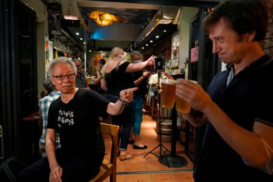 In this Oct. 9, 2020 photo, Grace Ma, left, chats with a customer at her bar Club 71 in Central, a business district of Hong Kong. Nearly 15 years ago, Ma decided to name her bar Club 71, in commemoration of a July 1, 2003 rally where hundreds of thousands of Hong Kongers protested a proposed national security law for the semi-autonomous Chinese city. (AP Photo/Kin Cheung) In this Oct. 9, 2020 photo, Grace Ma, left, chats with a customer at her bar Club 71 in Central, a business district of Hong Kong. Nearly 15 years ago, Ma decided to name her bar Club 71, in commemoration of a July 1, 2003 rally where hundreds of thousands of Hong Kongers protested a proposed national security law for the semi-autonomous Chinese city. (AP Photo/Kin Cheung)