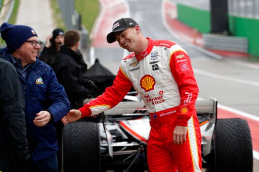 FILE  - In this Feb. 11, 2020, file photo, driver Scott McLaughlin, right, jokes with his crew and visitors during IndyCar Series auto racing testing in Austin, Texas. McLaughlin has nothing left to accomplish in Australia after wrapping up his third consecutive Supercars championship last weekend. He boarded a plane immediately after his final race and headed to the United States for his long-awaited IndyCar debut. McLaughlin was supposed to race for Team Penske in May but the pandemic pushed his tryout to Sunday's season finale on the streets of St. Petersburg. (AP Photo/Eric Gay, File)