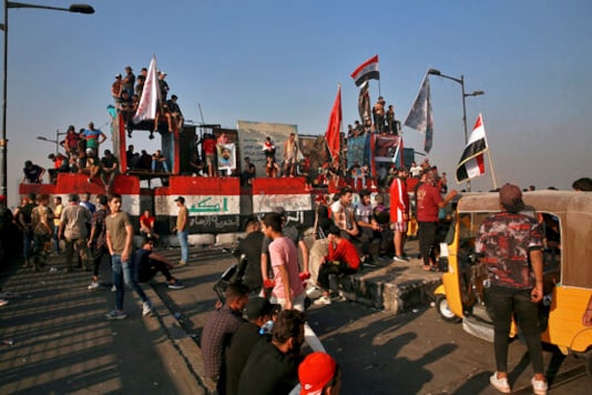 Anti-government protesters gather on the closed Joumhouriya Bridge that leads to the Green Zone government areas in Baghdad, Iraq, Sunday, Oct. 25, 2020. (AP Photo/Khalid Mohammed) Anti-government protesters gather on the closed Joumhouriya Bridge that leads to the Green Zone government areas in Baghdad, Iraq, Sunday, Oct. 25, 2020. (AP Photo/Khalid Mohammed)