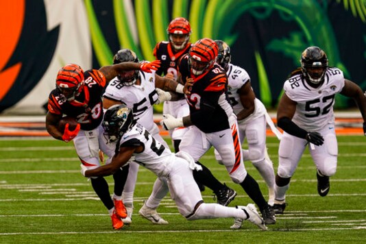 Cincinnati Bengals running back Joe Mixon (28) is tackled by Jacksonville Jaguars cornerback Chris Claybrooks (27) in the first half of an NFL football game in Cincinnati, Sunday, Oct. 4, 2020. (AP Photo/Bryan Woolston)