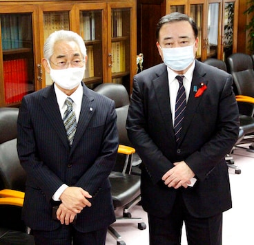 Japan's Industry Minister Hiroshi Kajiyama, right, and Suttsu Mayor Haruo Kataoka stand together during their meeting at the Ministry of Economy, Trade and Industry, in Tokyo Friday, Oct. 9, 2020. A pair of remote northern towns struggling with rapidly graining and shrinking populations signed up for a preliminary government studies to possibly build a final repository site for high-level radioactive waste from nuclear plants as a way of surviving.(Kyodo News via AP) Japan's Industry Minister Hiroshi Kajiyama, right, and Suttsu Mayor Haruo Kataoka stand together during their meeting at the Ministry of Economy, Trade and Industry, in Tokyo Friday, Oct. 9, 2020. A pair of remote northern towns struggling with rapidly graining and shrinking populations signed up for a preliminary government studies to possibly build a final repository site for high-level radioactive waste from nuclear plants as a way of surviving.(Kyodo News via AP)
