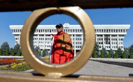 An activist stands in front of the Kyrgyz government headquarters on the central square in Bishkek, Kyrgyzstan, Wednesday, Oct. 7, 2020. Officials in Kyrgyzstan have nullified the results of a weekend parliamentary election after mass protests erupted in the capital of Bishkek and other cities, with opposition supporters seizing government buildings and demanding a new vote. (AP Photo/Vladimir Voronin) An activist stands in front of the Kyrgyz government headquarters on the central square in Bishkek, Kyrgyzstan, Wednesday, Oct. 7, 2020. Officials in Kyrgyzstan have nullified the results of a weekend parliamentary election after mass protests erupted in the capital of Bishkek and other cities, with opposition supporters seizing government buildings and demanding a new vote. (AP Photo/Vladimir Voronin)