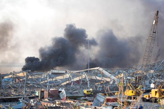 FILE - In this Aug. 4, 2020 file photo, smoke rises in the aftermath of a massive explosion in Beirut, Lebanon. The explosion took 193 lives and wounded 6,500. Among the dead are at least 43 Syrians, plunging a war-weary community into further misery. (AP Photo/Hassan Ammar, File) FILE - In this Aug. 4, 2020 file photo, smoke rises in the aftermath of a massive explosion in Beirut, Lebanon. The explosion took 193 lives and wounded 6,500. Among the dead are at least 43 Syrians, plunging a war-weary community into further misery. (AP Photo/Hassan Ammar, File)