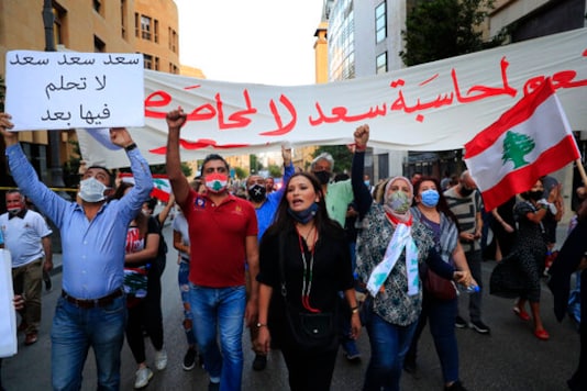Anti-government protesters shout slogans during a protest to denouncing the naming of former Prime Minister Saad Hariri as a potential candidate as the country's new prime minister, in downtown Beirut, Lebanon, Wednesday, Oct. 21, 2020. Hariri resigned a year ago amid nationwide protests against government corruption and mismanagement of Lebanon's resources. The Arabic placard reads: Anti-government protesters shout slogans during a protest to denouncing the naming of former Prime Minister Saad Hariri as a potential candidate as the country's new prime minister, in downtown Beirut, Lebanon, Wednesday, Oct. 21, 2020. Hariri resigned a year ago amid nationwide protests against government corruption and mismanagement of Lebanon's resources. The Arabic placard reads: