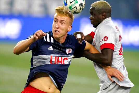 New England Revolution's Adam Buksa, left, vies for control of the ball with Toronto FC's Chris Mavinga during the first half of an MLS soccer match Wednesday, Oct. 7, 2020, in Foxborough, Mass. (AP Photo/Steven Senne)