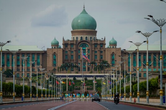 Motorists drive in front of the prime minister's office building in Putrajaya, Malaysia, Friday, Oct. 23, 2020. Malaysian opposition leader Anwar Ibrahim said Friday he was concerned about reports that Prime Minister Muhyiddin Yassi may invoke emergency laws to suspend Parliament and stymie bids to oust his government. (AP Photo/Vincent Thian)