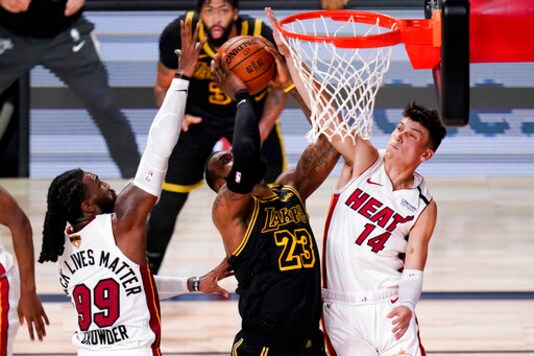 Los Angeles Lakers forward LeBron James scores between Miami Heat forward Jae Crowder, left, and guard Tyler Herro during the second half in Game 5 of basketball's NBA Finals Friday, Oct. 9, 2020, in Lake Buena Vista, Fla. (AP Photo/John Raoux)