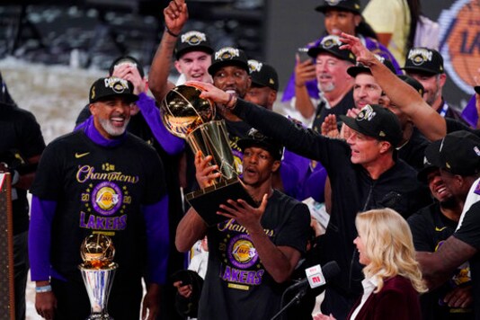 Los Angeles Lakers' Rajon Rondo (9) holds the trophy as he celebrates with his teammates after the Lakers defeated the Miami Heat 106-93 in Game 6 of basketball's NBA Finals Sunday, Oct. 11, 2020, in Lake Buena Vista, Fla. (AP Photo/Mark J. Terrill)