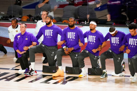 Members of the Los Angeles Lakers kneel as center Meyers Leonard stands before Game 6 of basketball's NBA Finals against the Miami Heat Sunday, Oct. 11, 2020, in Lake Buena Vista, Fla. (AP Photo/Mark J. Terrill) Members of the Los Angeles Lakers kneel as center Meyers Leonard stands before Game 6 of basketball's NBA Finals against the Miami Heat Sunday, Oct. 11, 2020, in Lake Buena Vista, Fla. (AP Photo/Mark J. Terrill)