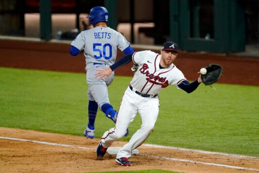Los Angeles Dodgers' Mookie Betts is save at first past Atlanta Braves first baseman Freddie Freeman during the sixth inning in Game 5 of a baseball National League Championship Series Friday, Oct. 16, 2020, in Arlington, Texas. (AP Photo/Tony Gutierrez)