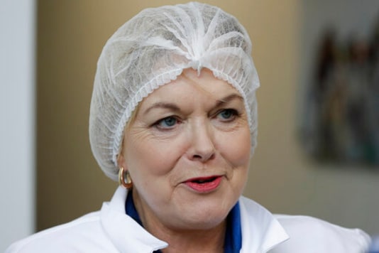 FILE - In this July 30, 2020, file photo, New Zealand opposition National Party leader Judith Collins, wearing a hairnet, waits to enter a salmon factory in Christchurch, New Zealand. New Zealand has suffered a steep economic downturn due to the virus and is borrowing billions of dollars to try and stem job losses and rebuild. National is promising to increase infrastructure spending. (AP Photo/Mark Baker, File) FILE - In this July 30, 2020, file photo, New Zealand opposition National Party leader Judith Collins, wearing a hairnet, waits to enter a salmon factory in Christchurch, New Zealand. New Zealand has suffered a steep economic downturn due to the virus and is borrowing billions of dollars to try and stem job losses and rebuild. National is promising to increase infrastructure spending. (AP Photo/Mark Baker, File)