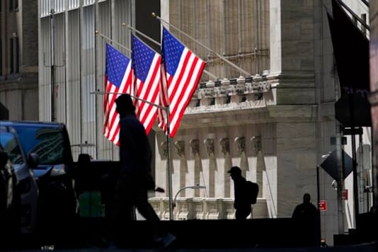 FILE - In this Oct. 14, 2020 file photo, pedestrians pass the New York Stock Exchange. After Donald Trump shocked markets by winning the presidency four years ago, investors quickly agreed on which stocks would benefit most from his election. But four years later, many of those stocks have since faded back, and stocks that were afterthoughts have become the market's leaders.   (AP Photo/Frank Franklin II)