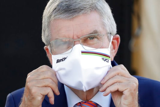 IOC President Thomas Bach waits for the podium ceremony for the women's elite event at the road cycling World Championships in Imola, Italy on Sept. 26, 2020. Organizers of a South Korean award say International Olympic Committee President Thomas Bach has decided not to visit in person this week and accept the prize because of concerns about the coronavirus pandemic. Bach was named winner of the Seoul Peace Prize last month and was to receive the award on Monday, Oct. 26, 2020. (AP Photo/Andrew Medichini) IOC President Thomas Bach waits for the podium ceremony for the women's elite event at the road cycling World Championships in Imola, Italy on Sept. 26, 2020. Organizers of a South Korean award say International Olympic Committee President Thomas Bach has decided not to visit in person this week and accept the prize because of concerns about the coronavirus pandemic. Bach was named winner of the Seoul Peace Prize last month and was to receive the award on Monday, Oct. 26, 2020. (AP Photo/Andrew Medichini)