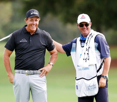 Winner Phil Mickelson gets a pat on the back from Jeff Johnson, the caddie for Retief Goosen, during final round play in the Dominion Energy Charity Classic at the Country Club of Virginia in Richmond, Virginia, on Sunday, October 18, 2020. Mickelson finished 3 strokes ahead of Canada's Mike Weir. (Joe Mahoney/Richmond Times-Dispatch via AP) Winner Phil Mickelson gets a pat on the back from Jeff Johnson, the caddie for Retief Goosen, during final round play in the Dominion Energy Charity Classic at the Country Club of Virginia in Richmond, Virginia, on Sunday, October 18, 2020. Mickelson finished 3 strokes ahead of Canada's Mike Weir. (Joe Mahoney/Richmond Times-Dispatch via AP)