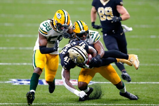 New Orleans Saints running back Alvin Kamara (41) is tackled by Green Bay Packers strong safety Adrian Amos (31) and inside linebacker Christian Kirksey (58) on a 49 yard run in the first half of an NFL football game in New Orleans, Sunday, Sept. 27, 2020. (AP Photo/Brett Duke)