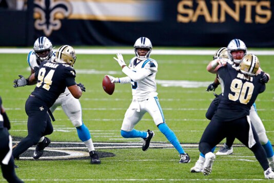Carolina Panthers quarterback Teddy Bridgewater scrambles under pressure from New Orleans Saints defensive end Cameron Jordan (94) and defensive tackle Malcom Brown (90) in the second half of an NFL football game in New Orleans, Sunday, Oct. 25, 2020. (AP Photo/Butch Dill)