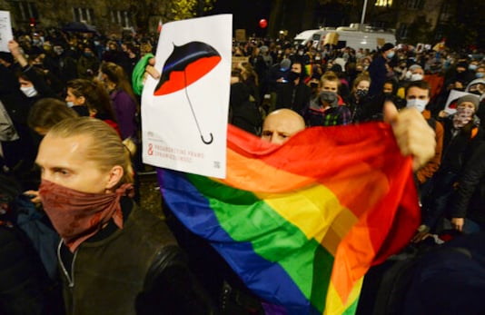 A crowd gathers outside the house of Poland's ruling conservative party leader Jaroslaw Kaczynski in Warsaw, Poland, Friday, Oct. 23, 2020. Protesters vented anger for a second day across Poland over a court ruling that declared abortions of fetuses with congenital defects unconstitutional. The hundreds of protesters who gathered in many cities defied a COVID-19-related ban on gatherings that was imposed nationwide on Friday. (AP Photo/Czarek Sokolowski)