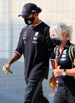 Mercedes driver Lewis Hamilton of Britain, left, walks near the track prior to the Formula One Portuguese Grand Prix at the Algarve International Circuit in Portimao, Portugal, Thursday, Oct. 22, 2020. The Formula One Portuguese Grand Prix will take place on Sunday. (AP Photo/Armando Franca)