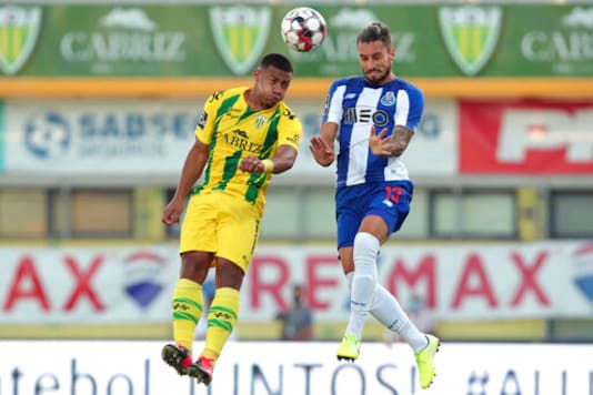 Porto's Alex Telles jumps for the ball against Tondela's Fahd Moufi during the Portuguese league soccer match between Tondela and FC Porto and Leipzig at the Joao Cardoso stadium in Tondela, Portugal, Thursday, July 9, 2020. The Portuguese league soccer matches are being played without spectators because of the coronavirus pandemic. (AP Photo/Luis Vieira) Porto's Alex Telles jumps for the ball against Tondela's Fahd Moufi during the Portuguese league soccer match between Tondela and FC Porto and Leipzig at the Joao Cardoso stadium in Tondela, Portugal, Thursday, July 9, 2020. The Portuguese league soccer matches are being played without spectators because of the coronavirus pandemic. (AP Photo/Luis Vieira)