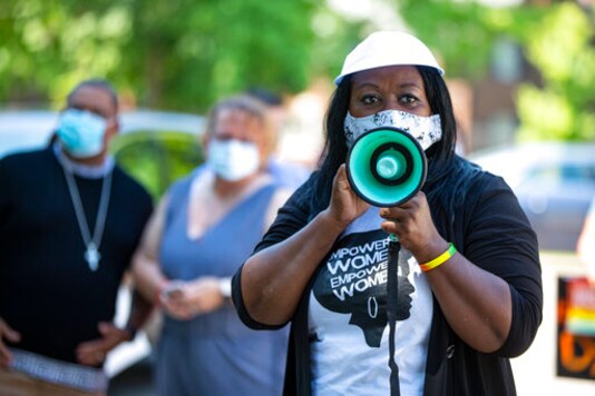 In this Friday, June 19, 2020, photo Jeannine Lee Lake, Democratic candidate for Indiana's 6th congressional district, speaks to the crowd gathered for Juneteenth day event in Columbus, Ind. The reenergized movement against racial inequality and police brutality following the killing of George Floyd in Minneapolis has amplified the voices of Black candidates across the country. Among them is Lake, who is challenging Rep. Greg Pence, the vice president's brother, in a deeply conservative Indiana district.  (AP Photo/Michael Conroy)