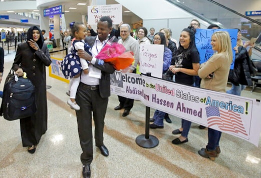 FILE - This Feb. 10, 2017, file photo, Abdisellam Hassen Ahmed, a Somali refugee who had been stuck in limbo after President Donald Trump temporarily banned refugee entries, walks with his wife Nimo Hashi, and his 2-year-old daughter, Taslim, who he met for the first time after arriving at Salt Lake City International Airport. President Trump appears to be ignoring a deadline to establish how many refugees will be allowed into the United States in 2021, raising uncertainty about the future of the 40-year-old resettlement program that has been dwindling under the administration. The 1980 Refugee Act requires presidents to issue their determination before Oct. 1, 2020, the start of the fiscal year. (AP Photo/Rick Bowmer, File)