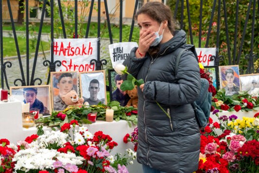 A woman reacts as she lays a flower at a symbolic memorial of victims of the military conflict in the separatist region of Nagorno-Karabakh at the Armenian Embassy in Moscow, Russia, Saturday, Oct. 17, 2020. Nagorno-Karabakh lies within Azerbaijan but has been under the control of ethnic Armenian forces backed by Armenia since a war there ended in 1994. The latest outburst of fighting began on Sept. 27 and has involved heavy artillery, rockets and drones, killing hundreds and marking the largest escalation of hostilities between the South Caucasus neighbors in more than a quarter-century. (AP Photo/Mikhail Kirakosyan) A woman reacts as she lays a flower at a symbolic memorial of victims of the military conflict in the separatist region of Nagorno-Karabakh at the Armenian Embassy in Moscow, Russia, Saturday, Oct. 17, 2020. Nagorno-Karabakh lies within Azerbaijan but has been under the control of ethnic Armenian forces backed by Armenia since a war there ended in 1994. The latest outburst of fighting began on Sept. 27 and has involved heavy artillery, rockets and drones, killing hundreds and marking the largest escalation of hostilities between the South Caucasus neighbors in more than a quarter-century. (AP Photo/Mikhail Kirakosyan)