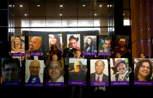 FILE - In this Dec. 7, 2015, file photo, San Bernardino County employees hold up photos of the San Bernardino shooting victims during a candlelight vigil in San Bernardino, Calif. Enrique Marquez Jr., who bought two rifles that a husband and wife used to kill 14 people in a California terror attack is expected to be sentenced. He is scheduled to appear in federal court Friday, Oct. 23, 2020 in Riverside. (AP Photo/Jae C. Hong, File) FILE - In this Dec. 7, 2015, file photo, San Bernardino County employees hold up photos of the San Bernardino shooting victims during a candlelight vigil in San Bernardino, Calif. Enrique Marquez Jr., who bought two rifles that a husband and wife used to kill 14 people in a California terror attack is expected to be sentenced. He is scheduled to appear in federal court Friday, Oct. 23, 2020 in Riverside. (AP Photo/Jae C. Hong, File)