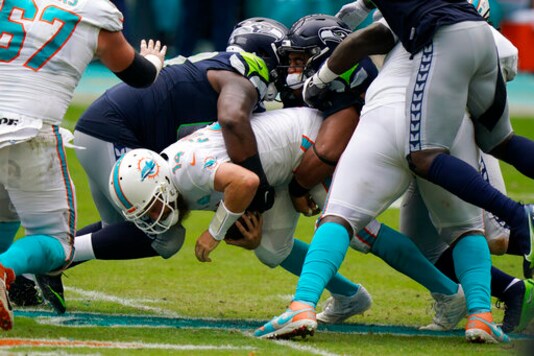 Miami Dolphins quarterback Ryan Fitzpatrick (14) is sacked by Seattle Seahawks defensive tackles Anthony Rush and Bryan Mone, during the first half of an NFL football game, Sunday, Oct. 4, 2020 in Miami Gardens, Fla. (AP Photo/Wilfredo Lee) Miami Dolphins quarterback Ryan Fitzpatrick (14) is sacked by Seattle Seahawks defensive tackles Anthony Rush and Bryan Mone, during the first half of an NFL football game, Sunday, Oct. 4, 2020 in Miami Gardens, Fla. (AP Photo/Wilfredo Lee)