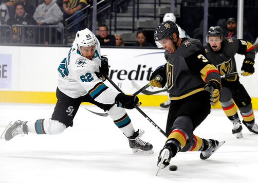 FILE - In this Oct. 2, 2019, file photo, San Jose Sharks' Kevin Labanc, left, shoots under Vegas Golden Knights defenseman Brayden McNabb during the first period of an NHL hockey game in Las Vegas. The Sharks have signed Labanc to a four-year deal worth just under $19 million. Labanc got a significant raise after making just $1 million last season. (AP Photo/Isaac Brekken, File)