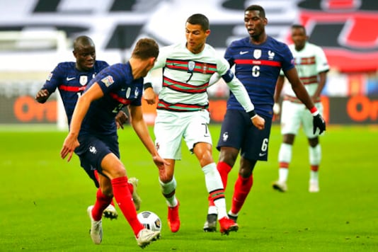 FILE - In this Sunday, Oct. 11, 2020 file photo Portugal's Cristiano Ronaldo, center, runs with the ball at France's Benjamin Pavard, foreground, between Ngolo Kante and Paul Pogba, right, during the UEFA Nations League soccer match between France and Portugal at the Stade de France in Saint-Denis, north of Paris, France. The Portuguese soccer federation says Cristiano Ronaldo has tested positive for the coronavirus. The federation says Ronaldo is doing well and has no symptoms. He has been dropped from the country's Nations League match against Sweden on Wednesday, Oct. 14. (AP Photo/Thibault Camus, File) FILE - In this Sunday, Oct. 11, 2020 file photo Portugal's Cristiano Ronaldo, center, runs with the ball at France's Benjamin Pavard, foreground, between Ngolo Kante and Paul Pogba, right, during the UEFA Nations League soccer match between France and Portugal at the Stade de France in Saint-Denis, north of Paris, France. The Portuguese soccer federation says Cristiano Ronaldo has tested positive for the coronavirus. The federation says Ronaldo is doing well and has no symptoms. He has been dropped from the country's Nations League match against Sweden on Wednesday, Oct. 14. (AP Photo/Thibault Camus, File)