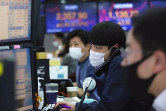 A currency trader talks on the phone at the foreign exchange dealing room of the KEB Hana Bank headquarters in Seoul, South Korea, Friday, Oct. 23, 2020. Shares were mostly higher in Asia on Friday after President Donald Trump and his challenger former Vice President Joe Biden faced off in their second and final debate before the Nov. 3 election. (AP Photo/Ahn Young-joon)