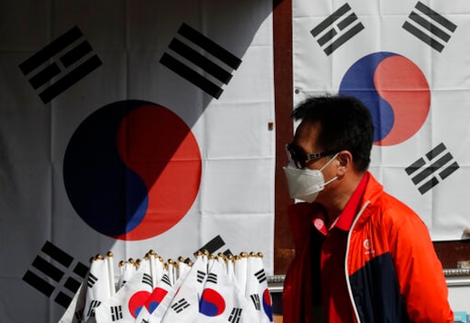 A man wearing a face mask walks near national flags displayed at a souvenir shop at the Imjingak Pavilion in Paju, South Korea, Sunday, Oct. 11, 2020. North Korean leader Kim Jong Un warned that his country would A man wearing a face mask walks near national flags displayed at a souvenir shop at the Imjingak Pavilion in Paju, South Korea, Sunday, Oct. 11, 2020. North Korean leader Kim Jong Un warned that his country would