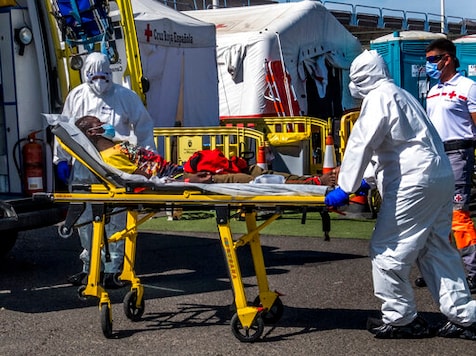 A migrant is taken on a stretcher by medical workers as he arrives with others migrants at the Arguineguin port in Gran Canaria island, Spain, after being rescued in the Atlantic Ocean by emergency workers on Tuesday, Oct.20, 2020. Some 1,000 migrants have spent the night again sleeping in emergency tents in a dock while authorities in the Canary Islands complain that the Spanish government keeps blocking transfers of newly arrived migrants to the mainland over coronavirus concerns. (AP Photo/Javier Bauluz) A migrant is taken on a stretcher by medical workers as he arrives with others migrants at the Arguineguin port in Gran Canaria island, Spain, after being rescued in the Atlantic Ocean by emergency workers on Tuesday, Oct.20, 2020. Some 1,000 migrants have spent the night again sleeping in emergency tents in a dock while authorities in the Canary Islands complain that the Spanish government keeps blocking transfers of newly arrived migrants to the mainland over coronavirus concerns. (AP Photo/Javier Bauluz)