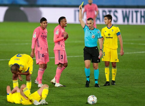 Real Madrid's Eder Militao, center, gets yellow cardduring the Spanish La Liga soccer match between Real Madrid and Cadiz at the Alfredo di Stefano stadium in Madrid, Spain, Saturday, Oct. 17, 2020. (AP Photo/Bernat Armangue) Real Madrid's Eder Militao, center, gets yellow cardduring the Spanish La Liga soccer match between Real Madrid and Cadiz at the Alfredo di Stefano stadium in Madrid, Spain, Saturday, Oct. 17, 2020. (AP Photo/Bernat Armangue)
