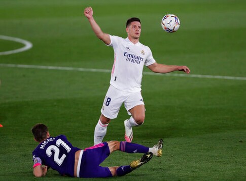 Real Madrid's Luka Jovic is stopped by Valladolid's Michel, bottom, during the Spanish La Liga soccer match between Real Madrid and Valladolid at Alfredo di Stefano stadium in Madrid, Spain, Wednesday, Sept. 30, 2020. (AP Photo/Manu Fernandez)