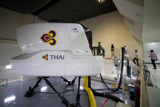 Customers enter into a Boeing A380 flight simulator for a flying experience at the Thai Airways head office in Bangkok, Thailand, Oct. 3, 2020. The airline is selling time on its flight simulators to wannabe pilots while its catering division is serving meals in a flight-themed restaurant complete with airline seats and attentive cabin crew. The airline is trying to boost staff morale, polish its image and bring in a few pennies, even as it juggles preparing to resume international flights while devising a business reorganization plan. (AP Photo/Sakchai Lalit) Customers enter into a Boeing A380 flight simulator for a flying experience at the Thai Airways head office in Bangkok, Thailand, Oct. 3, 2020. The airline is selling time on its flight simulators to wannabe pilots while its catering division is serving meals in a flight-themed restaurant complete with airline seats and attentive cabin crew. The airline is trying to boost staff morale, polish its image and bring in a few pennies, even as it juggles preparing to resume international flights while devising a business reorganization plan. (AP Photo/Sakchai Lalit)