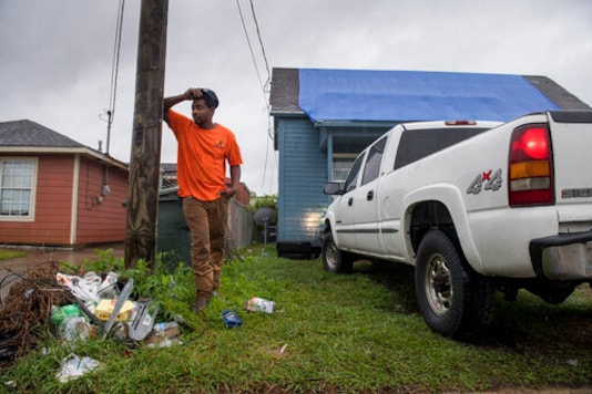 Standing in front of his house covered in a blue tarp from Hurricane Laura damage, Joshua Espree, 30, plans on staying in Lake Charles, La., and helping his family as Hurricane Delta approaches the area on Friday, Oct. 9, 2020. Delta is expected to make landfall late Friday. (Chris Granger /The Advocate via AP) Standing in front of his house covered in a blue tarp from Hurricane Laura damage, Joshua Espree, 30, plans on staying in Lake Charles, La., and helping his family as Hurricane Delta approaches the area on Friday, Oct. 9, 2020. Delta is expected to make landfall late Friday. (Chris Granger /The Advocate via AP)