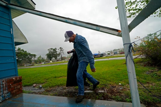 Jim Fontenot carries possessions into his brother's home, to which his family temporarily relocated to ride out Hurricane Delta which is expected to make landfall later in the day, in Lake Charles, La., Friday, Oct. 9, 2020. (AP Photo/Gerald Herbert) Jim Fontenot carries possessions into his brother's home, to which his family temporarily relocated to ride out Hurricane Delta which is expected to make landfall later in the day, in Lake Charles, La., Friday, Oct. 9, 2020. (AP Photo/Gerald Herbert)