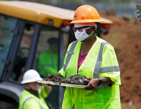 FILE - In this July 21, 2020, file photo, forensic anthropologist Phoebe Stubblefield carries a tray of items found at Oaklawn Cemetery during a test excavation in the search for possible mass graves from the 1921 Tulsa Race Massacre in Tulsa, Okla. A second excavation begins Monday, Oct. 19, 2020 at a Tulsa cemetery in search ofpeople killed inthe massacre in an effort to identify the victimsand shed light on the violence. (Mike Simons/Tulsa World via AP File) FILE - In this July 21, 2020, file photo, forensic anthropologist Phoebe Stubblefield carries a tray of items found at Oaklawn Cemetery during a test excavation in the search for possible mass graves from the 1921 Tulsa Race Massacre in Tulsa, Okla. A second excavation begins Monday, Oct. 19, 2020 at a Tulsa cemetery in search ofpeople killed inthe massacre in an effort to identify the victimsand shed light on the violence. (Mike Simons/Tulsa World via AP File)