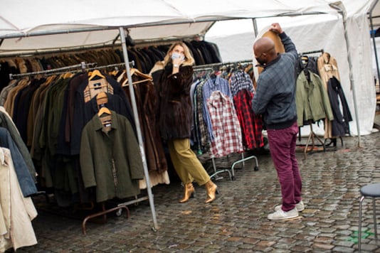 A customer, wearing a face mask to fight against the spread of the coronavirus, tries on a coat at Marolles flea market in Brussels, Tuesday, Oct. 13, 2020. Authorities in Belgium, one of the European countries hit hardest by the coronavirus, are warning that the number of cases is rising at a A customer, wearing a face mask to fight against the spread of the coronavirus, tries on a coat at Marolles flea market in Brussels, Tuesday, Oct. 13, 2020. Authorities in Belgium, one of the European countries hit hardest by the coronavirus, are warning that the number of cases is rising at a