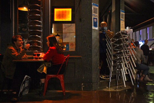 A worker packs away chairs outside a bar in Soho, London, ahead of the 10pm curfew pubs and restaurants are subject to in order to combat the rise in coronavirus cases in England, Friday, Oct. 2, 2020. (Kirsty O'Connor/PA via AP) A worker packs away chairs outside a bar in Soho, London, ahead of the 10pm curfew pubs and restaurants are subject to in order to combat the rise in coronavirus cases in England, Friday, Oct. 2, 2020. (Kirsty O'Connor/PA via AP)