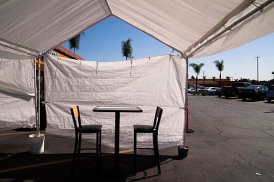 FILE - In this Sept. 30, 2020 file photo, a table, and chairs are set up in the outdoor dining area of a restaurant at a strip mall in La Mirada, Calif. California's financially battered restaurants filed government claims Monday to recover more than $100 million in fees for liquor and health permits and tourism charges that they say were assessed even though their businesses were shuttered or only partially operating under long-running coronavirus orders. Few industries have been hit as hard during the pandemic as restaurants. (AP Photo/Jae C. Hong, File) FILE - In this Sept. 30, 2020 file photo, a table, and chairs are set up in the outdoor dining area of a restaurant at a strip mall in La Mirada, Calif. California's financially battered restaurants filed government claims Monday to recover more than $100 million in fees for liquor and health permits and tourism charges that they say were assessed even though their businesses were shuttered or only partially operating under long-running coronavirus orders. Few industries have been hit as hard during the pandemic as restaurants. (AP Photo/Jae C. Hong, File)
