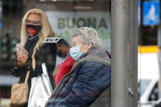 People wear face masks to prevent the spread of COVID-19 as they wait at a bus stop, in Milan, Italy, Wednesday, Oct. 14, 2020. Italian Premier Giuseppe Conte says the aim of Italy's new anti-virus restrictions limiting nightlife and socializing is to head off another generalized lockdown. (AP Photo/Luca Bruno) People wear face masks to prevent the spread of COVID-19 as they wait at a bus stop, in Milan, Italy, Wednesday, Oct. 14, 2020. Italian Premier Giuseppe Conte says the aim of Italy's new anti-virus restrictions limiting nightlife and socializing is to head off another generalized lockdown. (AP Photo/Luca Bruno)