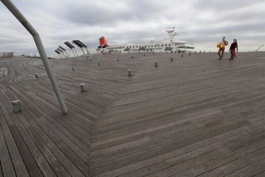 People wearing face masks to protect against the spread of the new coronavirus walk along pier of Yokohama, near Tokyo, Monday, Oct. 12, 2020. (AP Photo/Koji Sasahara) People wearing face masks to protect against the spread of the new coronavirus walk along pier of Yokohama, near Tokyo, Monday, Oct. 12, 2020. (AP Photo/Koji Sasahara)
