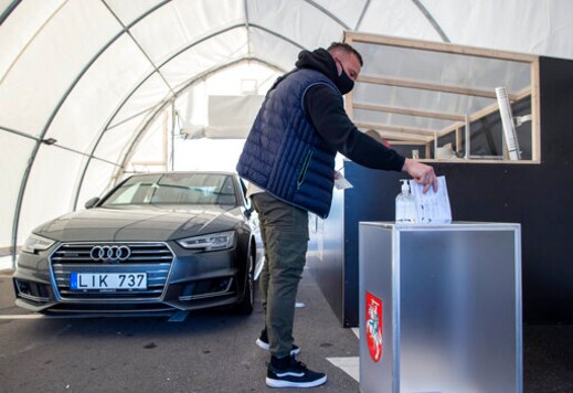 A voter, wearing face masks to protect against coronavirus casts his ballot on the first day of early voting in the second round of a parliamentary election at a drive-in polling station, special place of advance voting for self isolated voters in Vilnius, Lithuania, Monday, Oct. 19, 2020. Lithuanians are voting in the second round of a parliamentary election on Sunday during the rise in the incidence of coronavirus infection in the country. (AP Photo / Mindaugas Kulbis) A voter, wearing face masks to protect against coronavirus casts his ballot on the first day of early voting in the second round of a parliamentary election at a drive-in polling station, special place of advance voting for self isolated voters in Vilnius, Lithuania, Monday, Oct. 19, 2020. Lithuanians are voting in the second round of a parliamentary election on Sunday during the rise in the incidence of coronavirus infection in the country. (AP Photo / Mindaugas Kulbis)