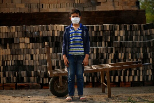 Ronnie, 10, wearing a mask to curb the spread of the new coronavirus, poses for a portrait as he works alongside his father at a small brick factory in Tobati, Paraguay, Monday, Aug. 31, 2020. Members of brickmaking families said school closures, scheduled to last at least until December, have led to many children and adolescents working longer hours, making it difficult to complete their virtual schoolwork. (AP Photo/Jorge Saenz) Ronnie, 10, wearing a mask to curb the spread of the new coronavirus, poses for a portrait as he works alongside his father at a small brick factory in Tobati, Paraguay, Monday, Aug. 31, 2020. Members of brickmaking families said school closures, scheduled to last at least until December, have led to many children and adolescents working longer hours, making it difficult to complete their virtual schoolwork. (AP Photo/Jorge Saenz)