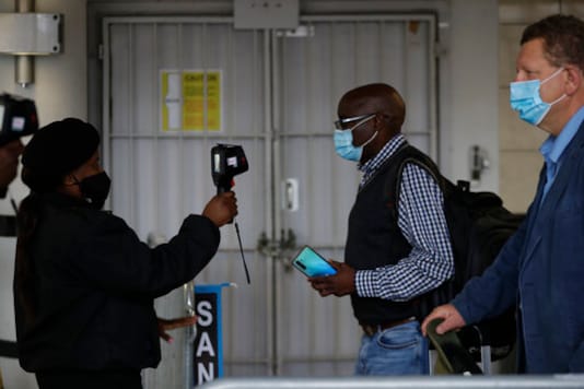 FILE In this Thursday, Oct. 1, 2020 file photo passengers have their temperatures taken at the International O.R. Tambo Airport in Johannesburg, South African Health Minister, Zwerli Mkhize announced Monday, Oct. 19 2020 that he and his wife have tested positive for COVID-19, warning of a possible resurgence of the disease in the country. (AP Photo/Themba Hadebe/File) FILE In this Thursday, Oct. 1, 2020 file photo passengers have their temperatures taken at the International O.R. Tambo Airport in Johannesburg, South African Health Minister, Zwerli Mkhize announced Monday, Oct. 19 2020 that he and his wife have tested positive for COVID-19, warning of a possible resurgence of the disease in the country. (AP Photo/Themba Hadebe/File)